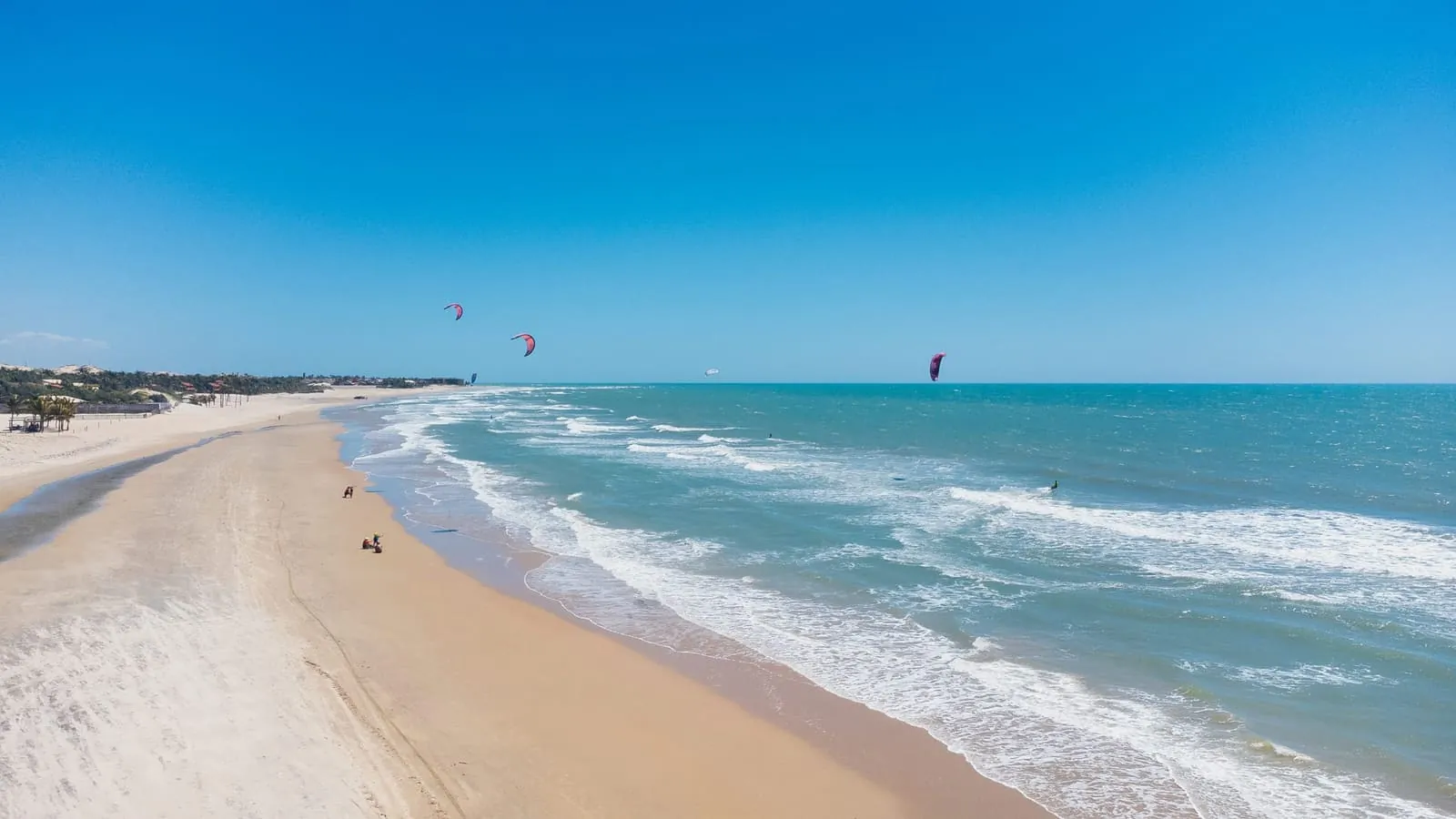 Vista aérea de praia com kitesurfistas no litoral cearense